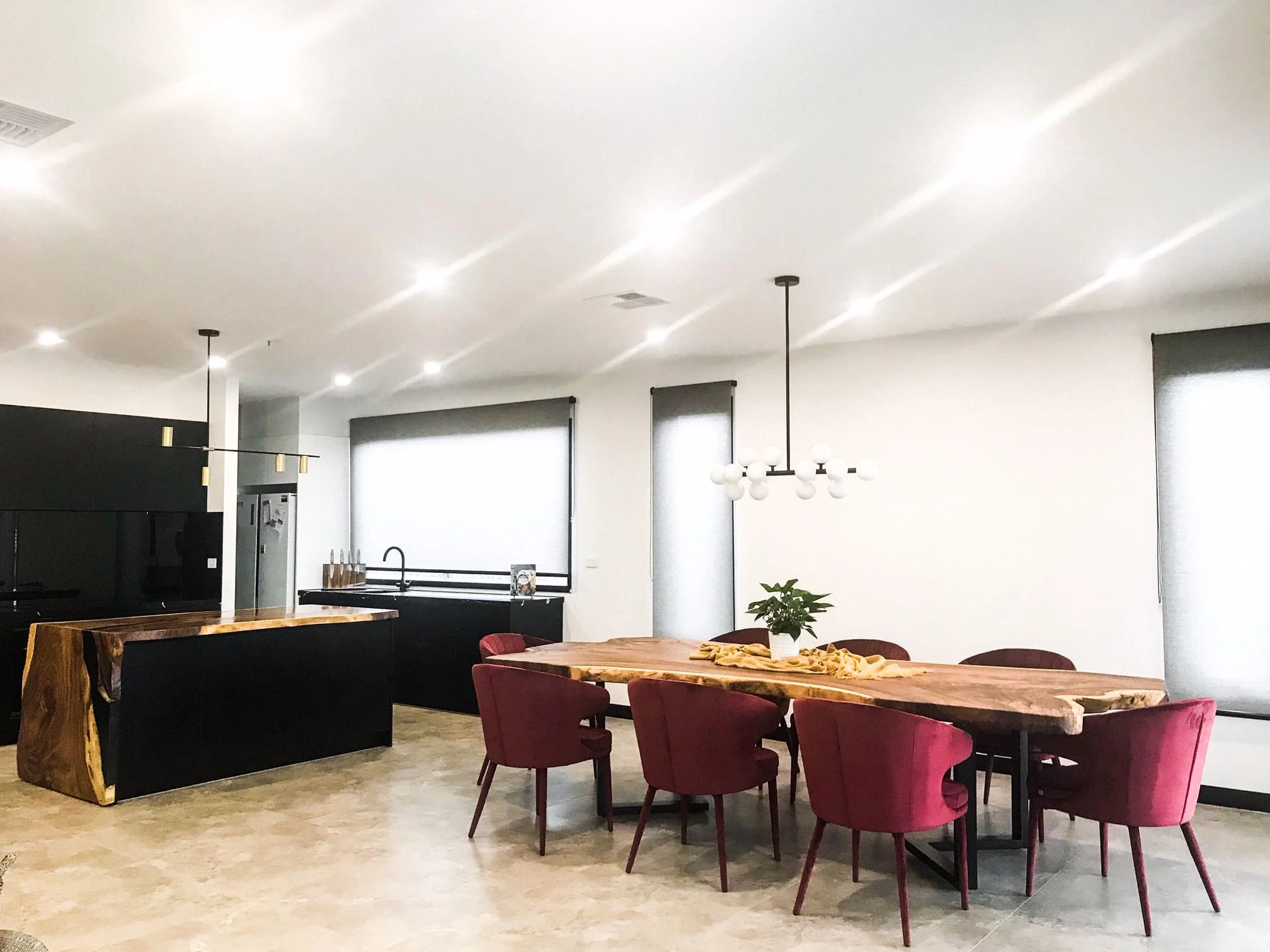 B-Spoke kitchen with black cabinetry, natural timber island and dining table, and burgundy chairs