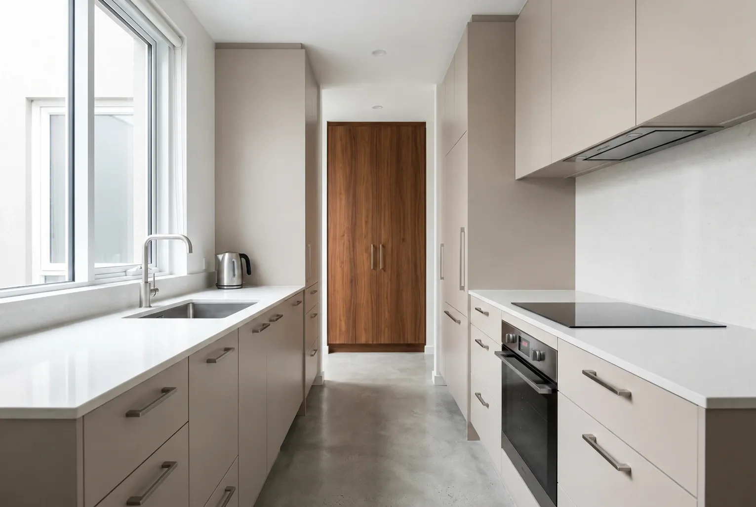 Compact galley kitchen inspiration with mushroom cabinetry, a walnut pantry and opposing preparation benches