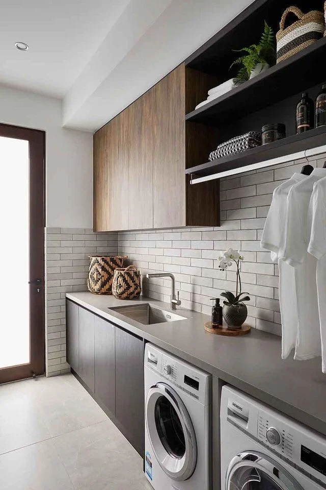 laundry with dark timber cabinetry, stone worktop and hanging rail