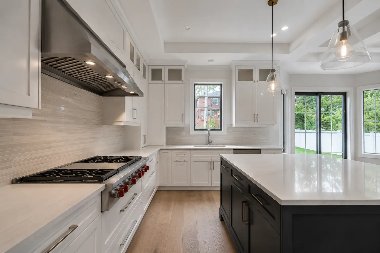 Warm kitchen interior with timber cabinetry, stone surfaces and a garden outlook